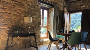 A rustic room with stone walls, a wooden table, and chairs. - Villa in the Ribeira Sacra, O Batuxo (Pantón (Lugo))