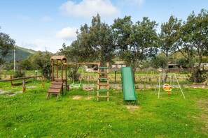Un parque infantil con columpios, tobogán y estructura para escalar.