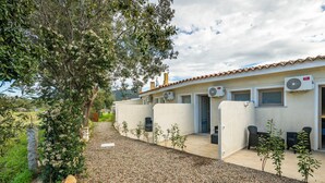 A building with a tiled roof, air conditioning units, and outdoor seating. - Mia Rooms: Double Room Three with Private Bathroom (Villasimius)