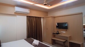 Une chambre d’hôtel équipée d’un lit, d’une télévision, d’un bureau et d’une armoire.