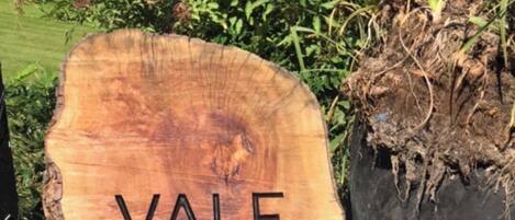 Un gran letrero de madera con el texto "VALE FARM" grabado.
