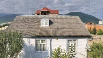 A house with a sloped roof, a small window, and a red roof.