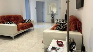 Ein modernes Wohnzimmer mit zwei Sofas, einem Couchtisch und einer Stehlampe.