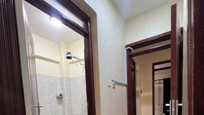 A bathroom with a shower, a toilet, and a mirror.