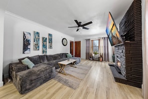 Smart TV, lareira, livros, aparelho de som