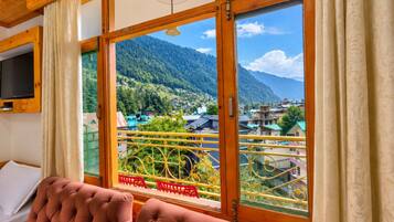 Una habitación con un ventanal que ofrece vistas a un paisaje montañoso.