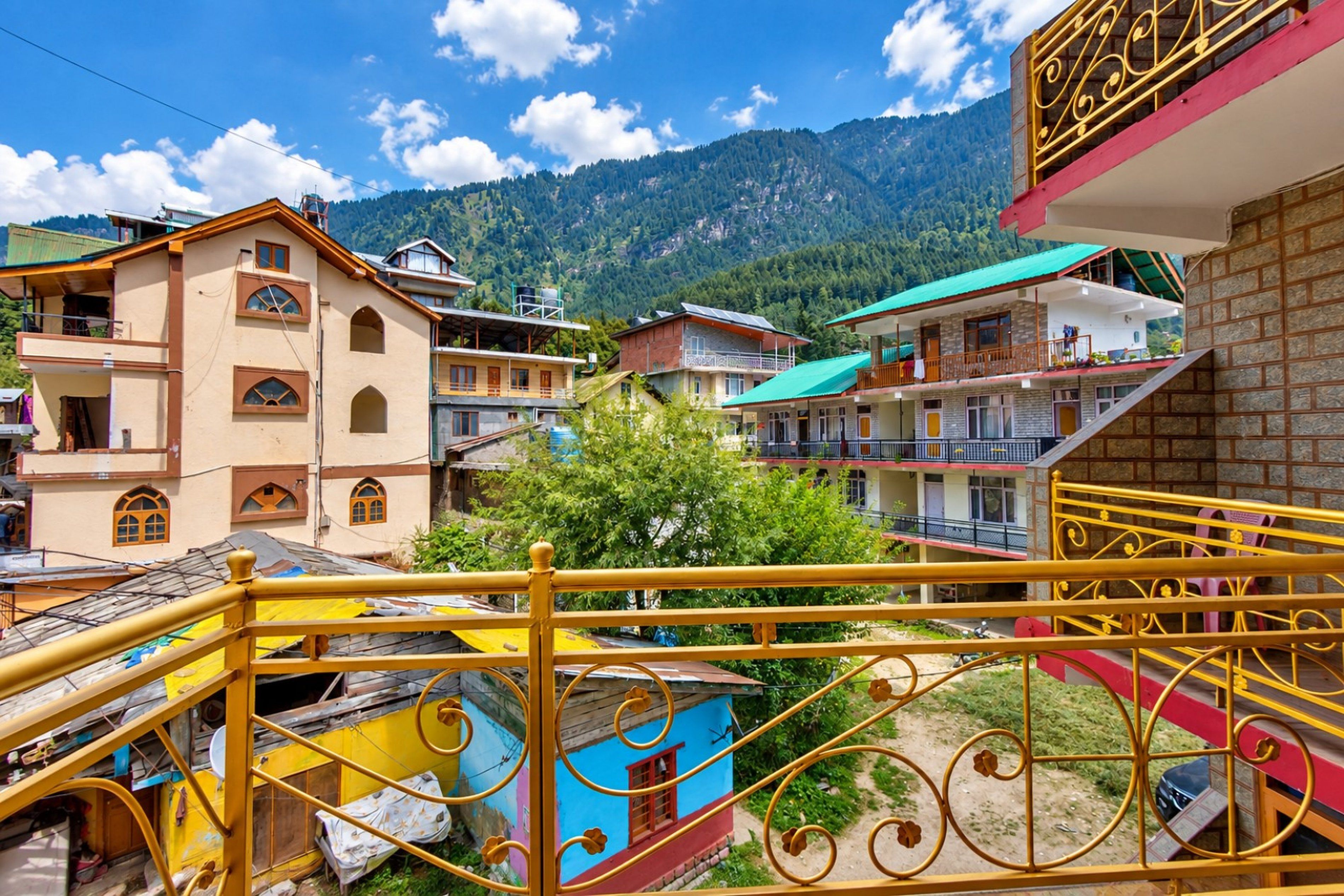 A residential area with multi-story buildings, a visible balcony, and a mountainous backdrop.