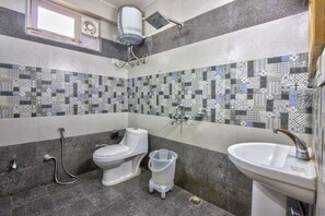 Un baño con inodoro, bidé, ducha y lavamanos.
