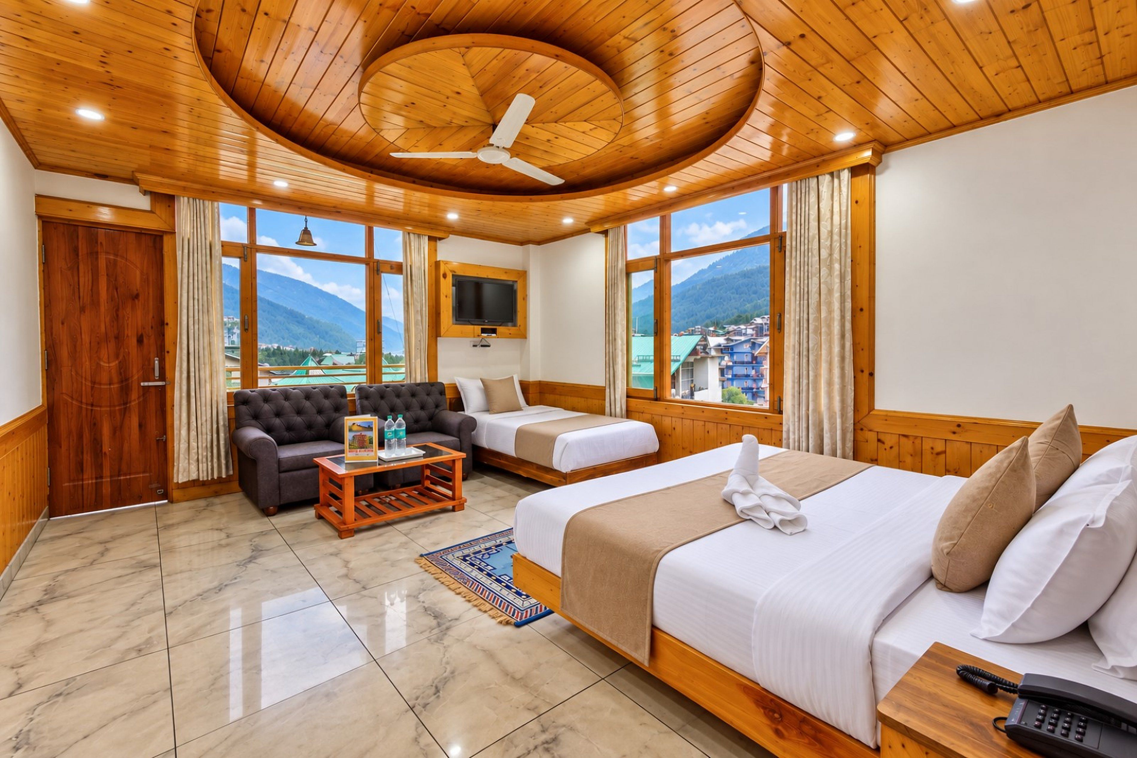 A hotel room with a bed, sofa, and a TV.
