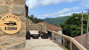 Un muro di pietra con un cartello di legno che recita 'BENVIDOS A DORNA'.