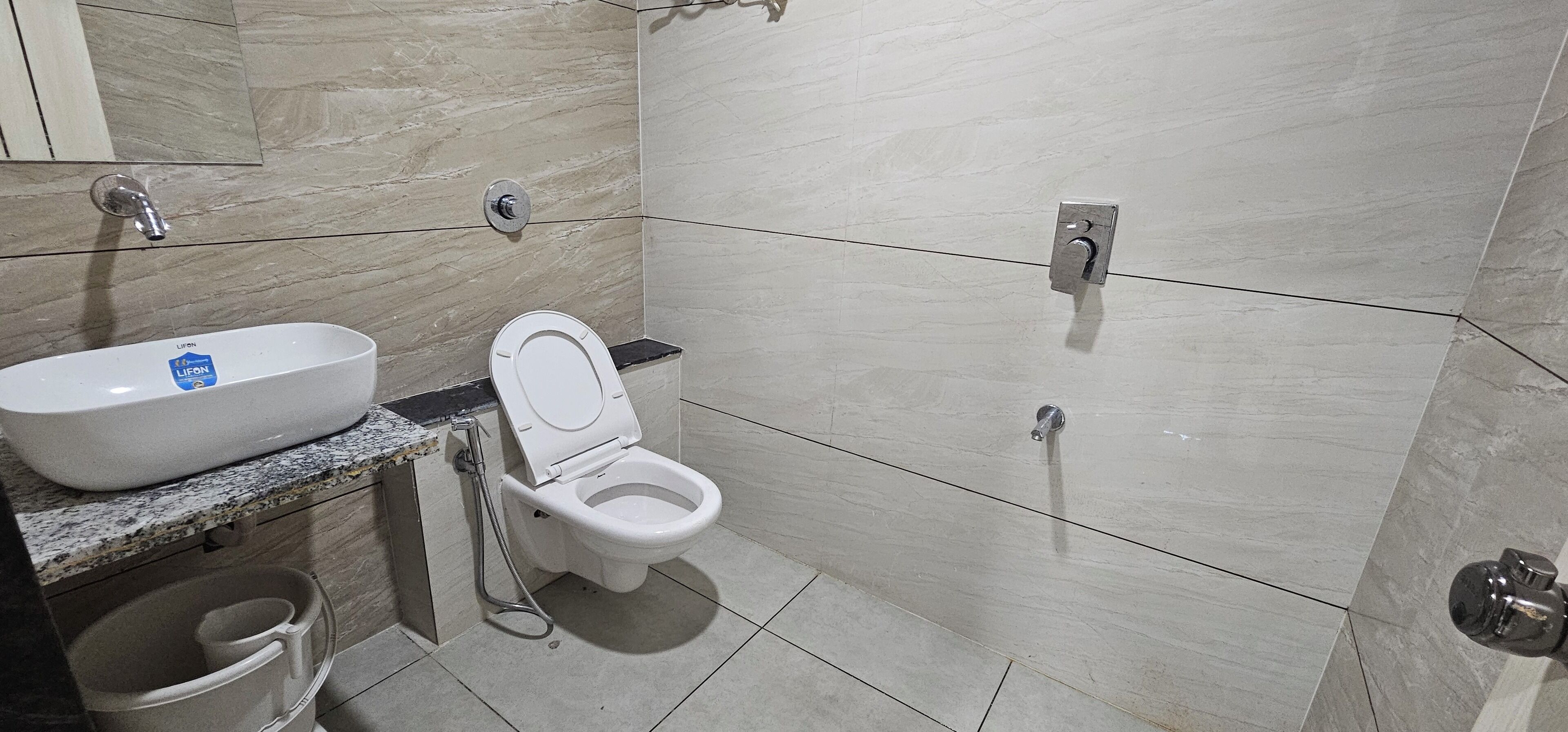 Un baño con lavamanos, inodoro y ducha blancos.