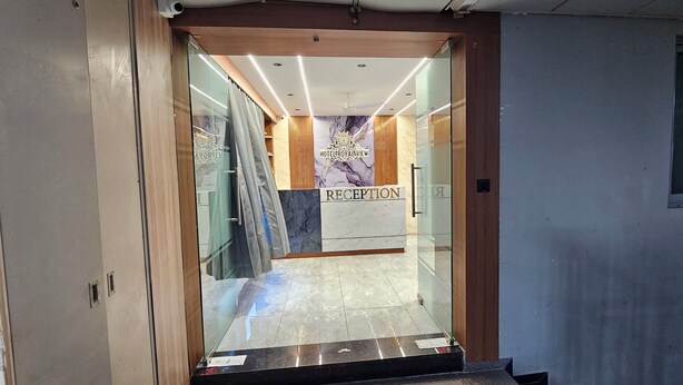 A reception area with a marble floor, wooden accents, and a sign that reads "RECEPTION". - HOTEL ROYAL VIEW (Ahmedabad)
