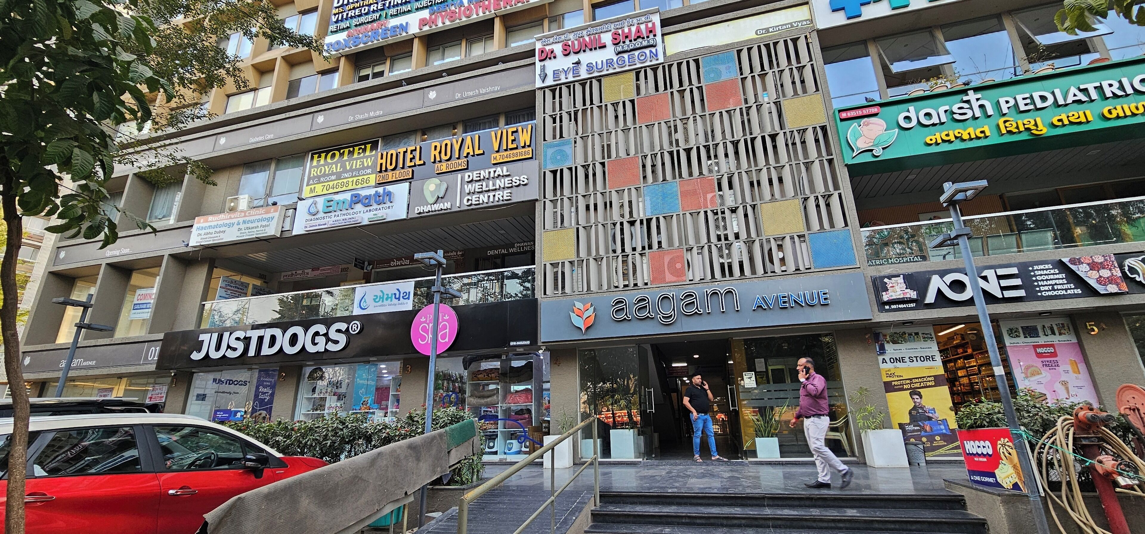 Un edificio de varios pisos que alberga diversos negocios, incluyendo un hotel, una clínica pediátrica y un centro de bienestar dental.