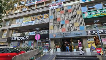 Un edificio de varios pisos que alberga diversos negocios, incluyendo un hotel, una clínica pediátrica y un centro de bienestar dental.