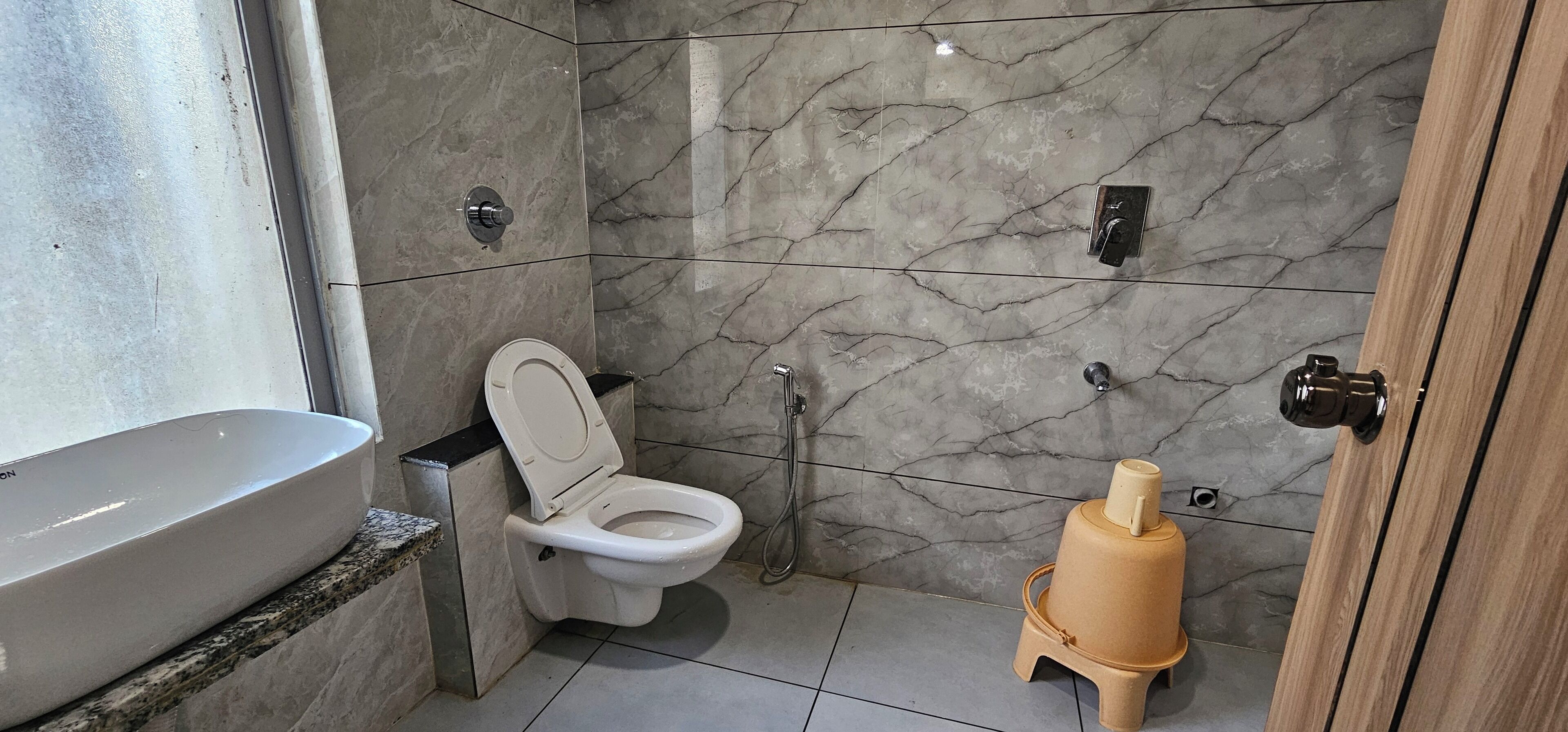 A bathroom with a toilet, a sink, a shower, and a large water heater.