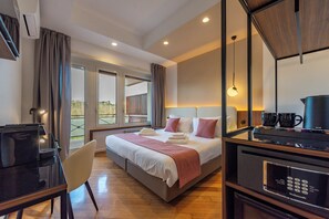 A hotel room with a bed, a desk, a chair, a coffee machine, and a view of the outdoors. - Relais Pamphili guest house by Ghor (Rome)