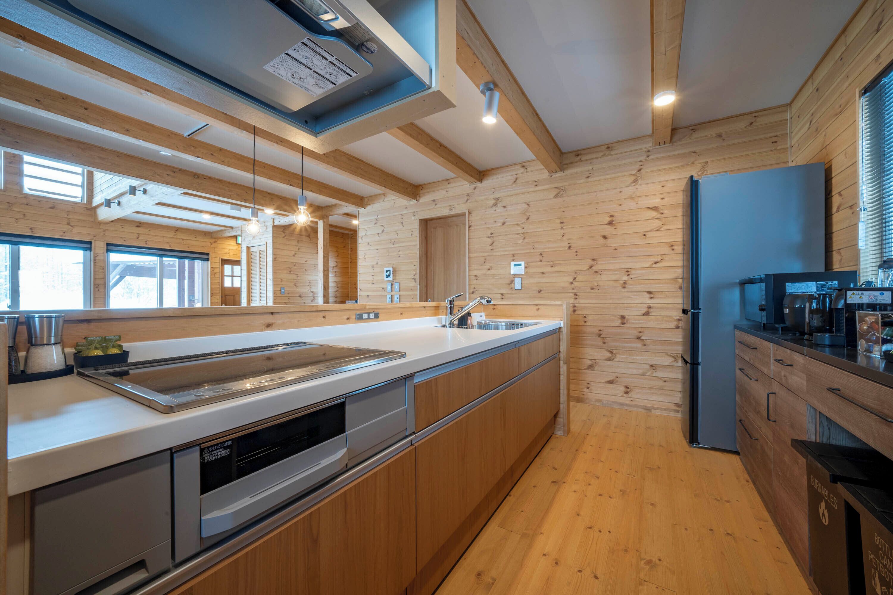 Een moderne keuken met houten wanden, een roestvrijstalen spoelbak en een inbouwoven.