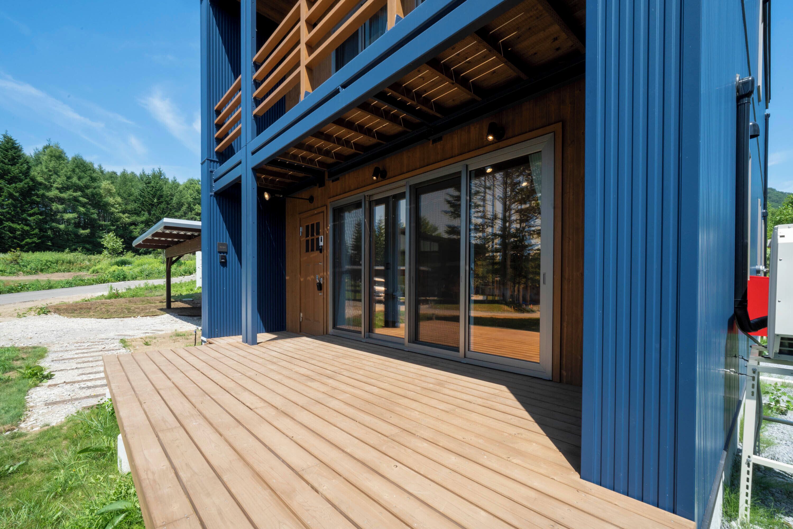 A modern building with a wooden deck and large glass windows.