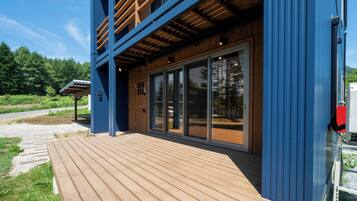 A modern building with a wooden deck and large glass windows.