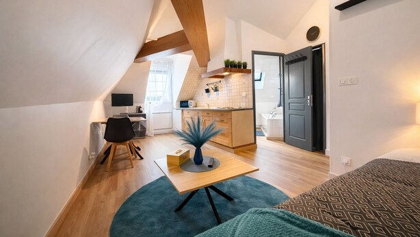 A compact, modern apartment with a loft-style bedroom, a kitchenette, and a dining area. - Cosy studio in the center of town (Redon)