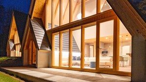 Una casa moderna con amplios ventanales y fachada de madera.