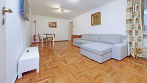 A living room with a sofa, a small table, a chair, and a fireplace. - Pantheon Apartment (roma)