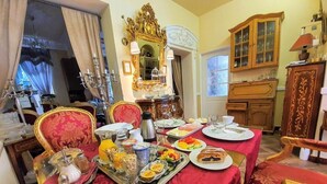 A dining area with a red tablecloth, ornate chairs, and a chandelier. - REZIDENCE ZÁMEČEK - BOUTIQUE HOTEL (Františkovy Lázně)