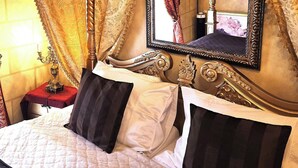 A bed with a white quilt, black and white striped pillows, and a red bedside table. - REZIDENCE ZÁMEČEK - BOUTIQUE HOTEL (Františkovy Lázně)