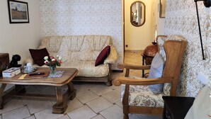 A cozy living room with a patterned sofa, a wooden coffee table, and a vintage armchair. - REZIDENCE ZÁMEČEK - BOUTIQUE HOTEL (Františkovy Lázně)