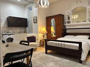 A bedroom with a bed, a nightstand, a mirror, and a dresser. There is a window with a view of the outside. - Room-lancaster Gate Studio Bayswater Roa (London)