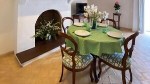 A dining area with a wooden ceiling, a fireplace, and a table set for four. - pieve san biagio (Macerata)