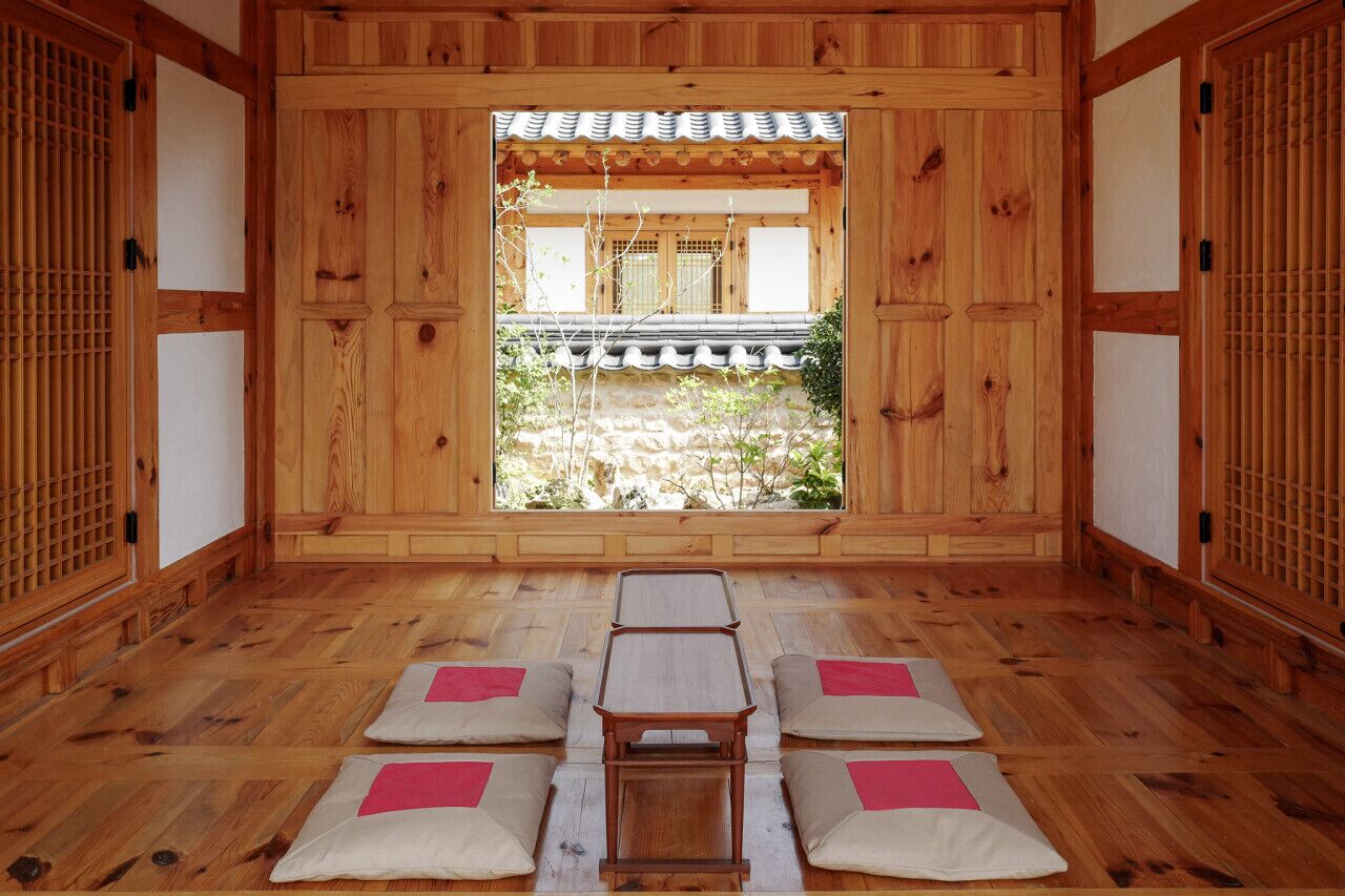 A traditional Japanese room with tatami mats, a low table, and sliding doors.