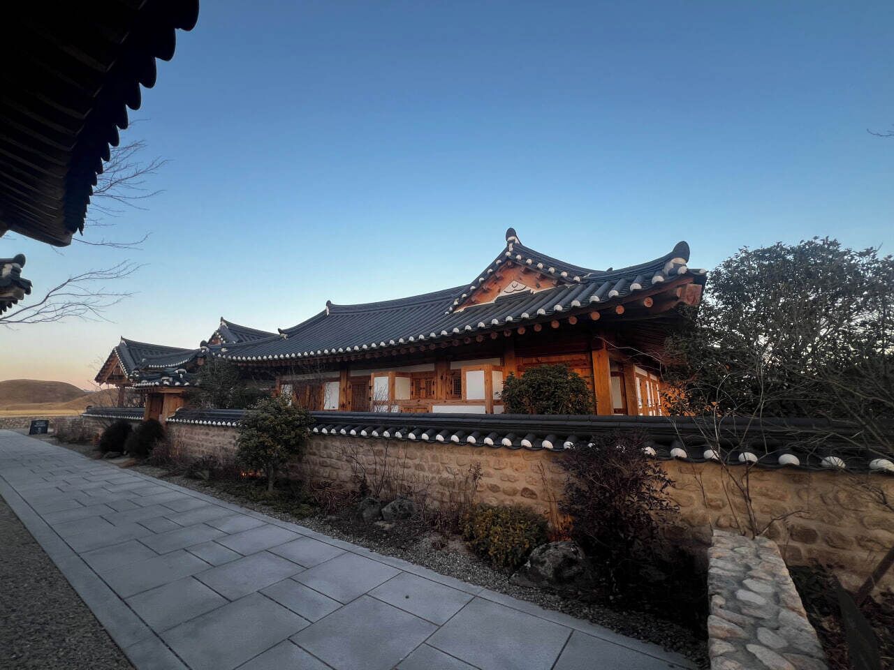 Een traditioneel Koreaans gebouw met een pannendak, houten wanden en een stenen fundering.