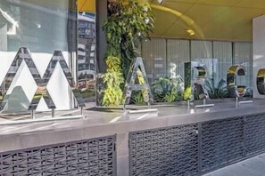 A reception desk with large, metallic letters spelling out the hotel's name. - Marco Prestige | City Views | Pool, Gym (Southbank)