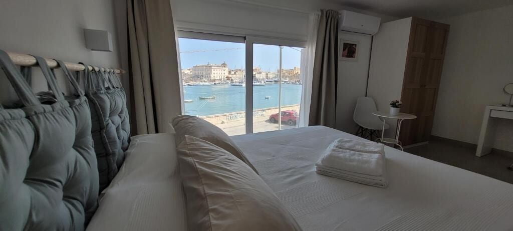 Una habitación de hotel con una cama, un escritorio, una silla y vista al mar.