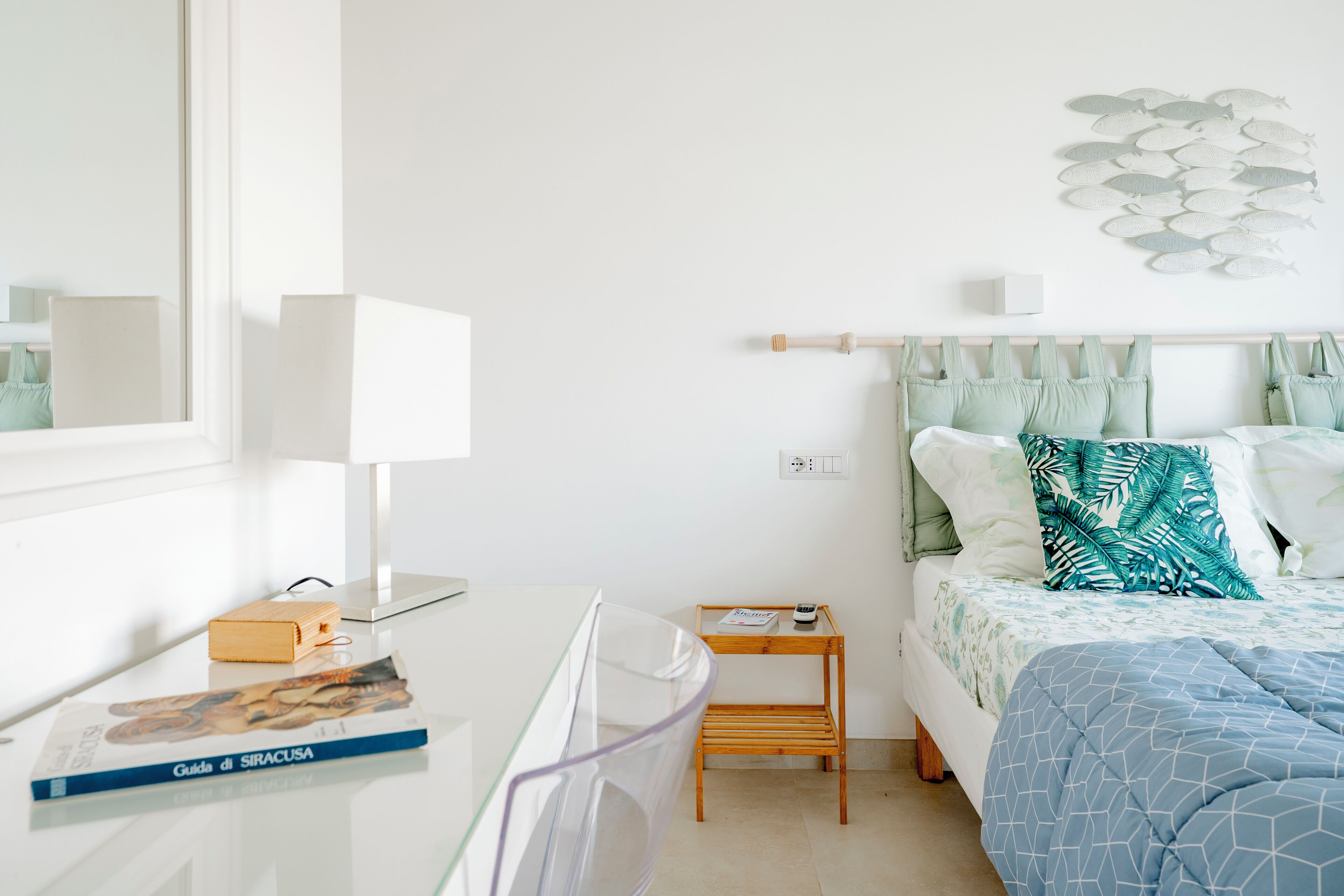 A modern bedroom with a bed, a bedside table, a lamp, and a wall art piece.