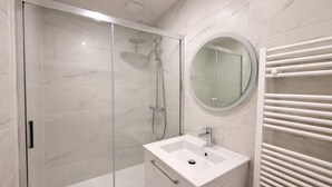 A modern bathroom with a glass-enclosed shower, a white sink, and a towel rack. - Charmant appartement a Aubervilliers, 4 personnes (Aubervilliers)