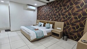 Camera da letto con un letto, comodini, televisione, condizionatore d'aria e parete decorata.