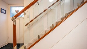 Eine Holztreppe mit Glastrennläufen und einer Teppichstufe.