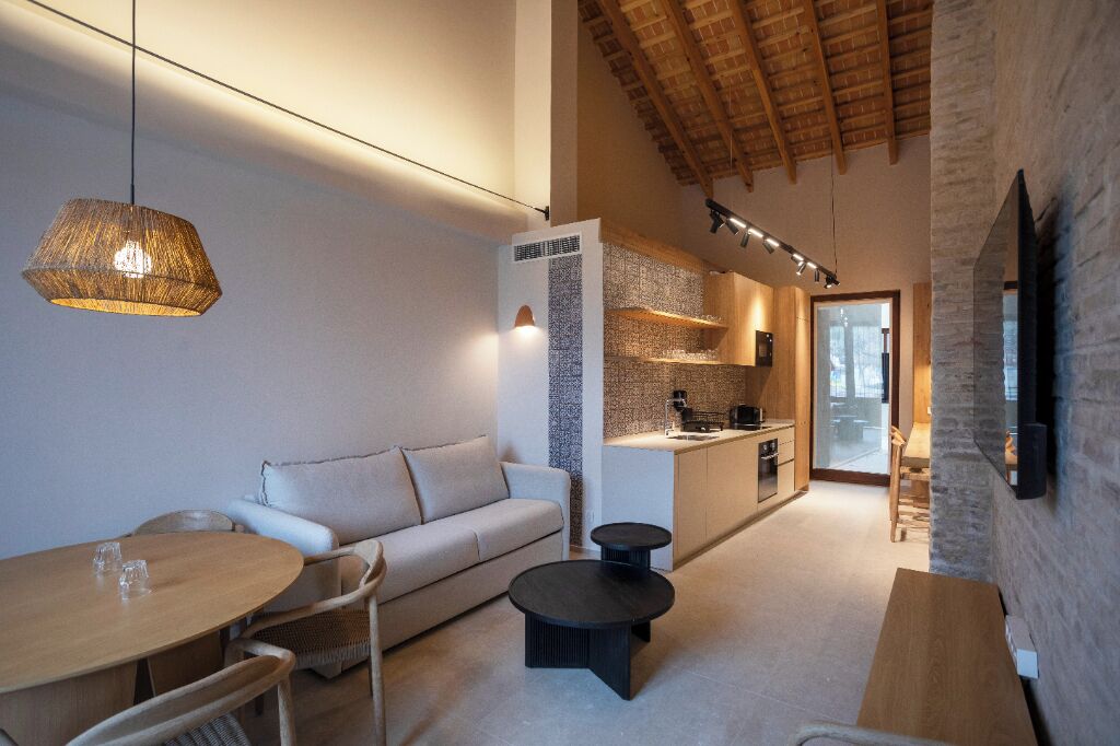 Un espacio habitable moderno con sofá, mesa de comedor y zona de cocina.
