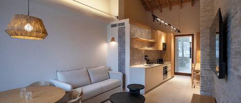 Un espacio habitable moderno con sofá, mesa de comedor y zona de cocina.