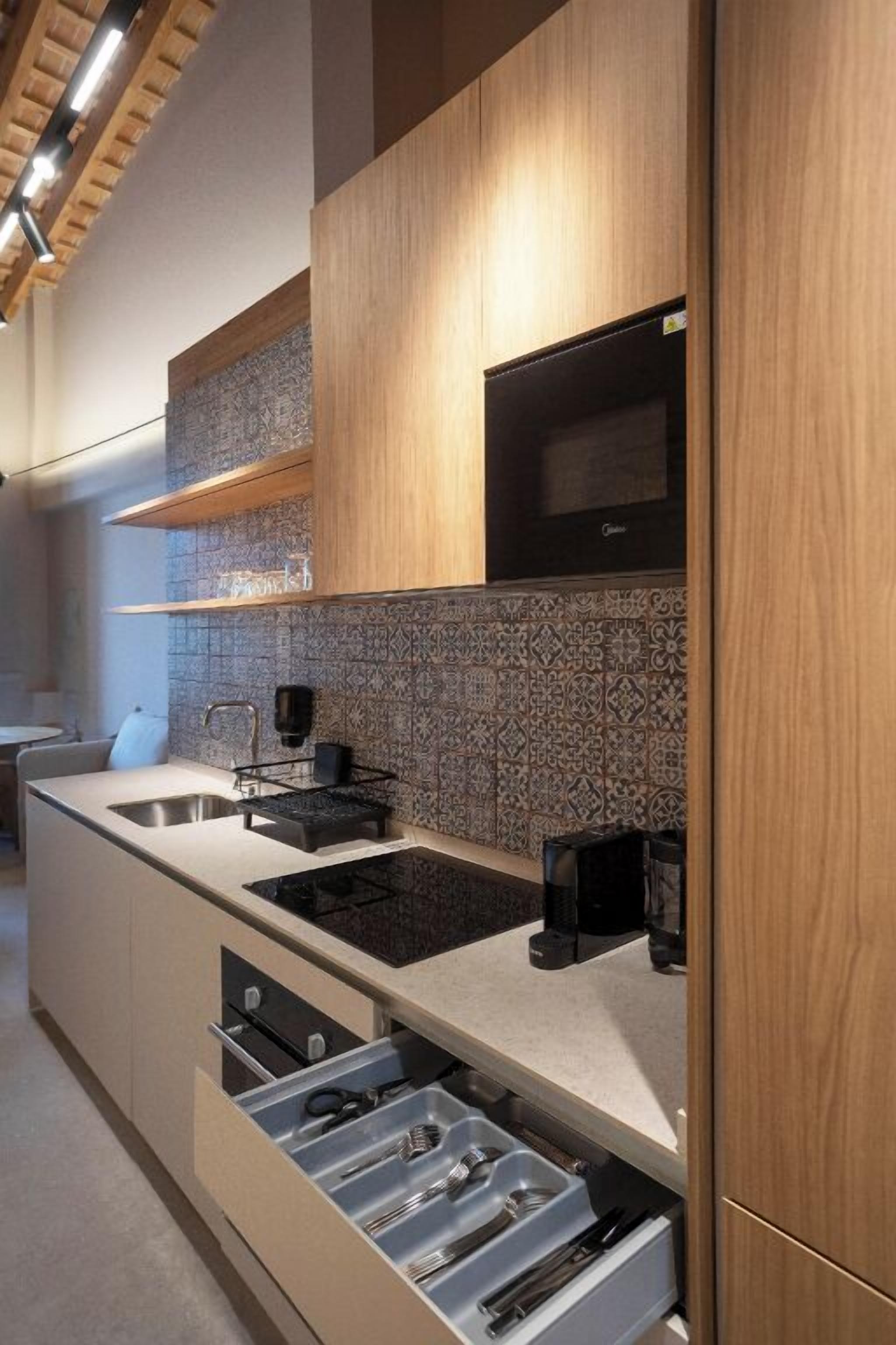 Una cocina moderna con armarios de madera, estufa integrada y un salpicadero con diseño.