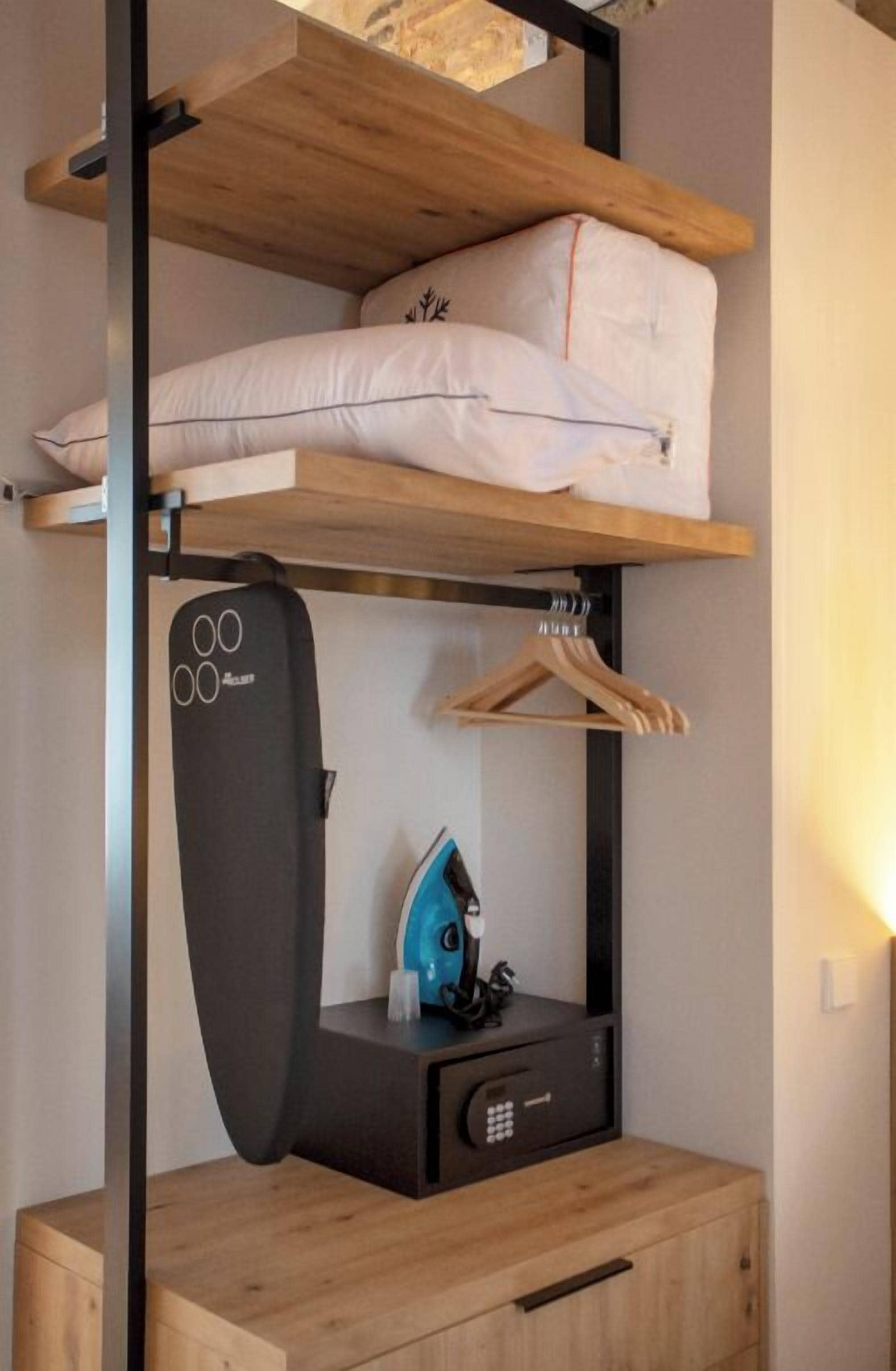 Ein kleines Zimmer mit Etagenbett, einem Schreibtisch inklusive Tastatur und einer Kleiderstange.