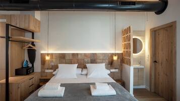 A modern hotel room with a large bed, wooden headboard, and a built-in circular light fixture.