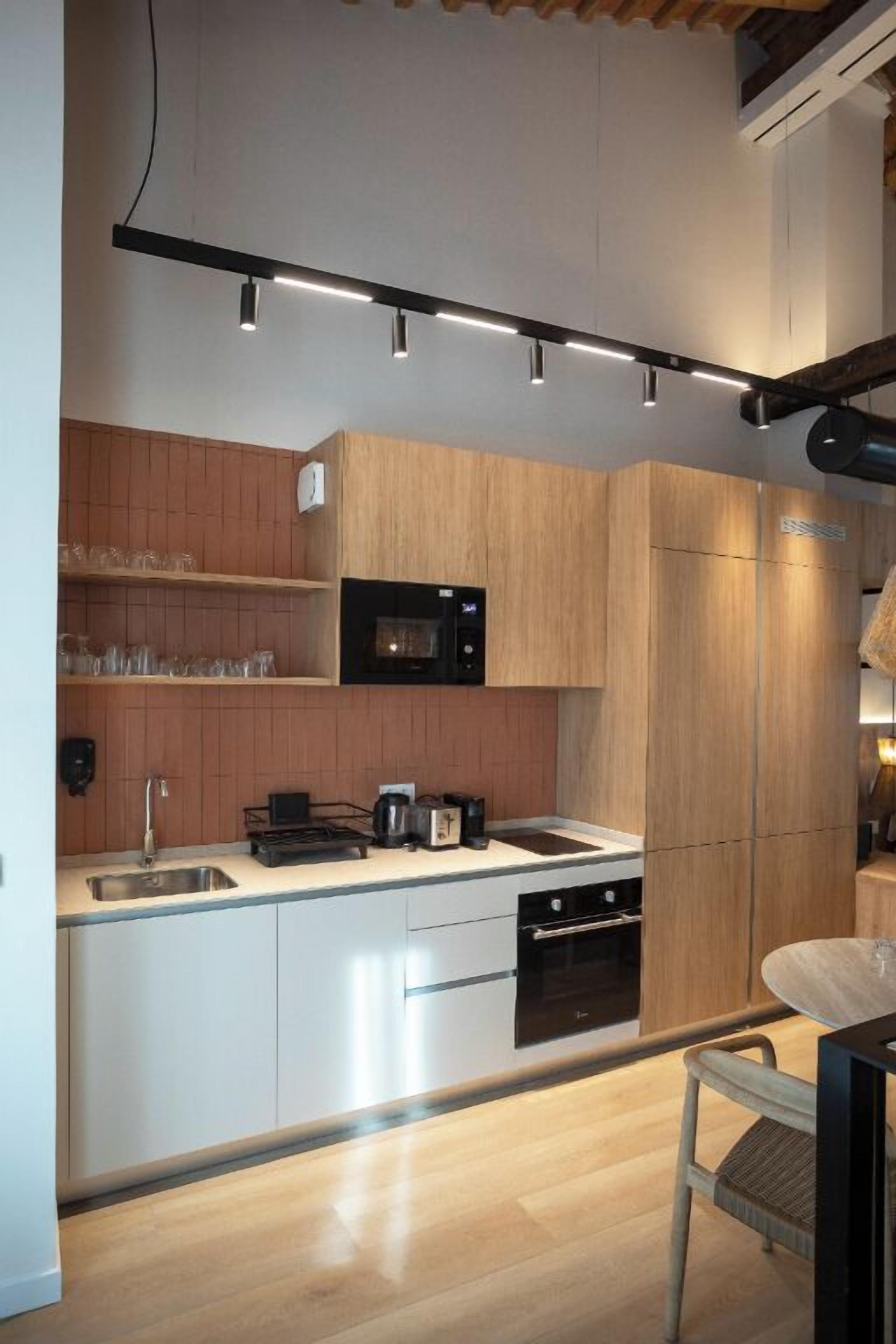 A modern kitchen with wooden cabinets, a black microwave, and a built-in oven.