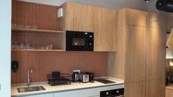 A modern kitchen with wooden cabinets, a black microwave, and a built-in oven.