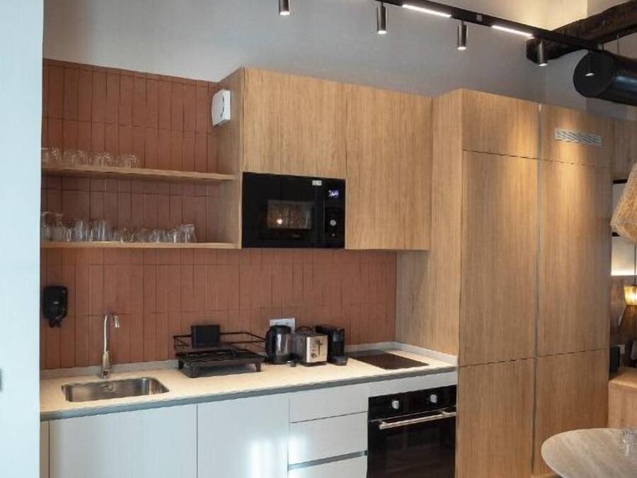 A modern kitchen with wooden cabinets, a black microwave, and a built-in oven.