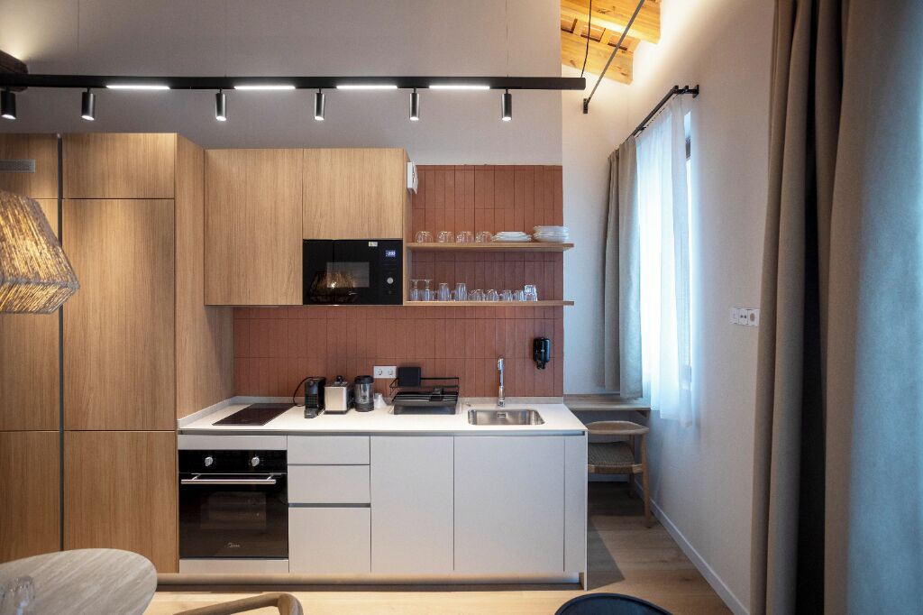 Een moderne keuken met houten kastjes, een inbouwoven en een centraal kookeiland met spoelbak.