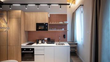 Eine moderne Küche mit Holzschränken, einem eingebauten Backofen und einer zentralen Kochinsel mit Spüle.
