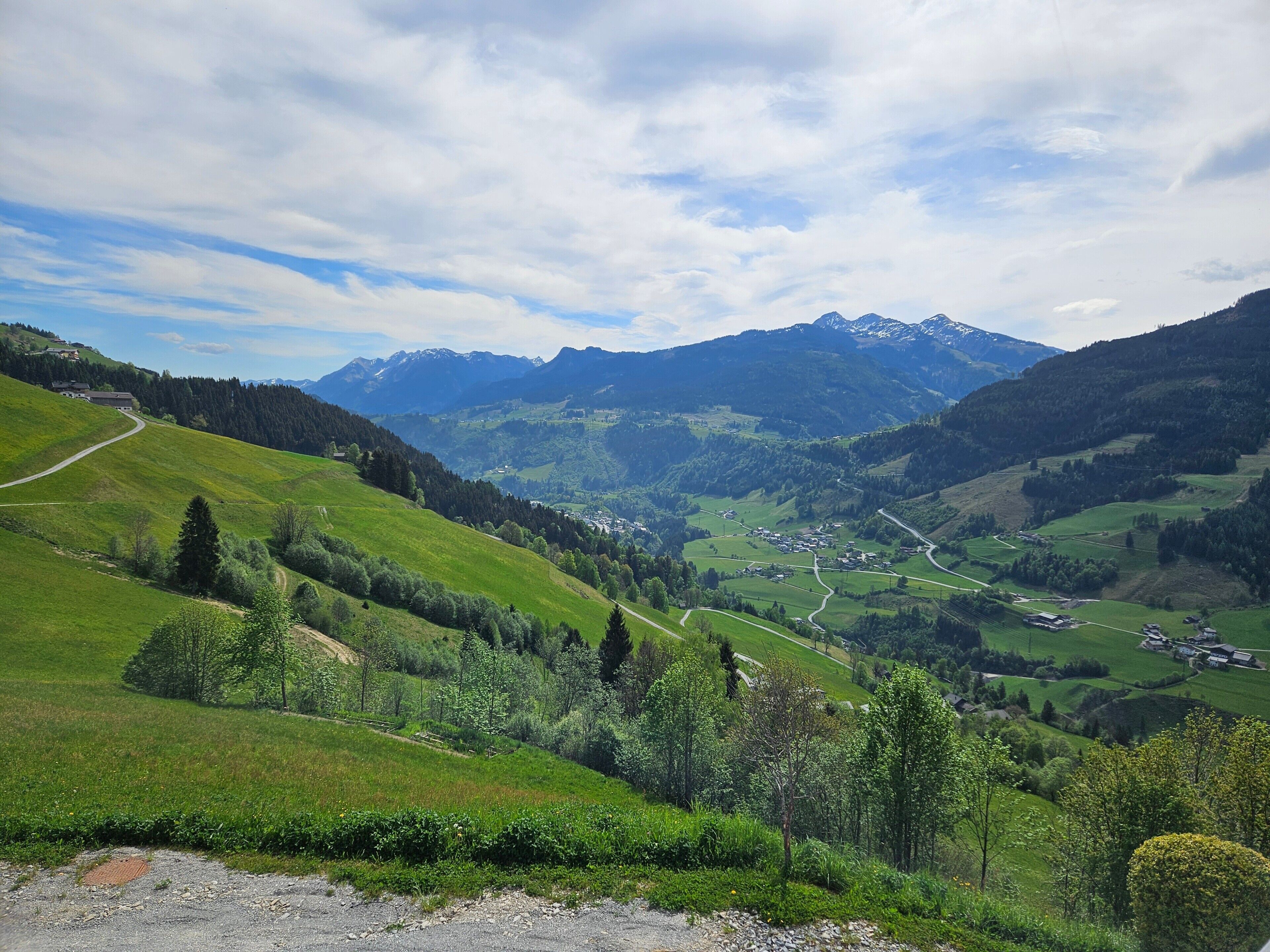 A mountainous landscape with a valley, roads, and scattered buildings.